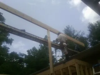 Carpenter setting a ridge beam over a new addition frame — Ice Dam Removal by Roofing Brothers in Shoemakersville