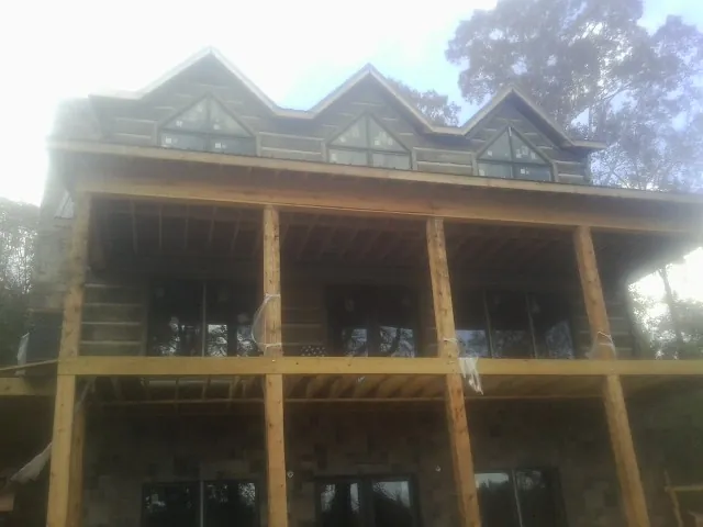 Dormers and porch framing on a large log home under construction — Roof Coating work by our crew in Shoemakersville